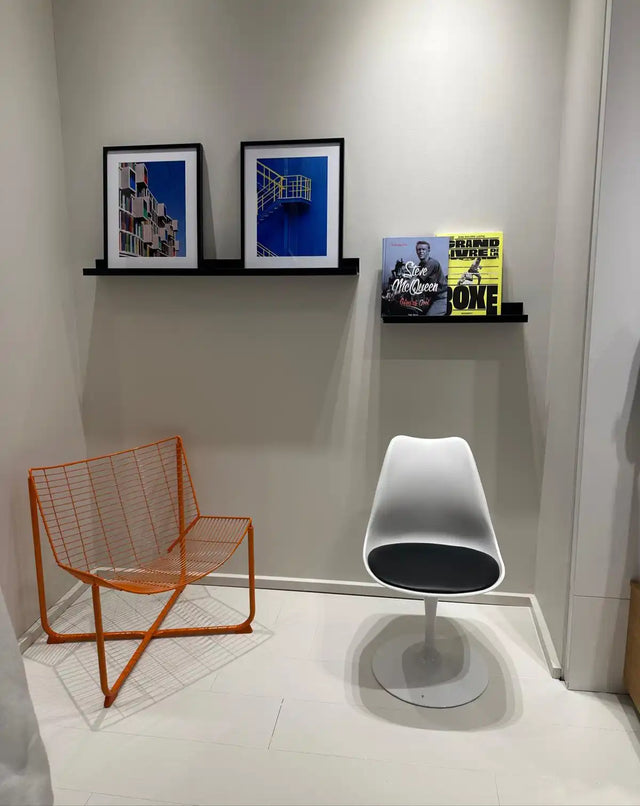 Espace de vie moderne avec deux chaises distinctives et une œuvre d'art encadrée.