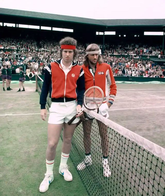 Deux joueurs de tennis masculins en tenues de sport rouges et blancs tenant des raquettes de tennis.