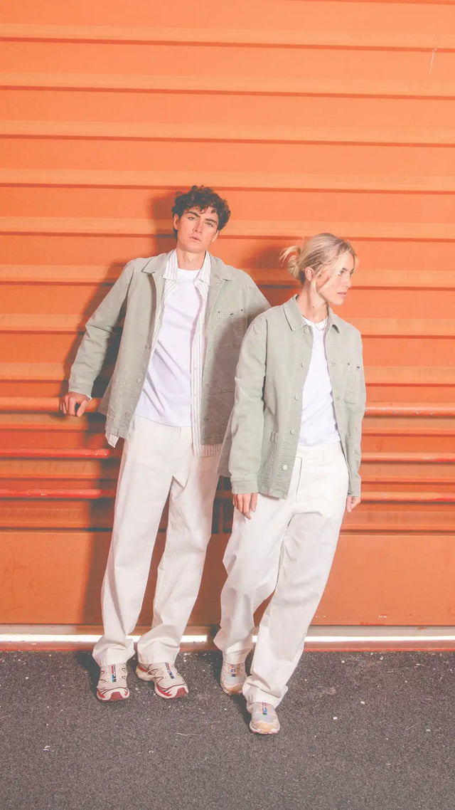 Veste utilitaire verte olive avec chemise blanche et pantalon beige, tenue décontractée.