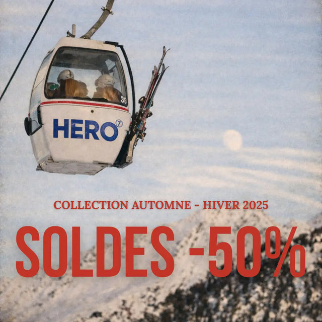 Téléphérique blanc de héros avec marquage rouge et bleu, transportant des skieurs sur un fond de montagne enneigée.