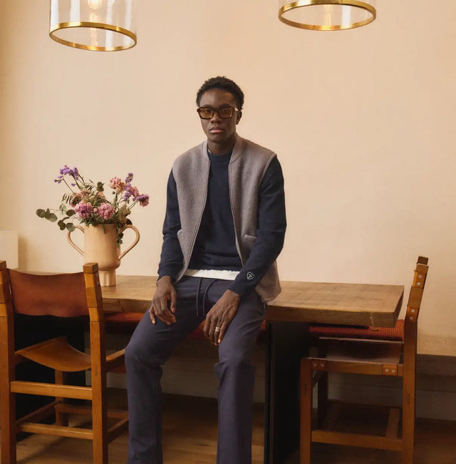 Veste en laine bleu marine avec bordure blanche et boutons dorés.